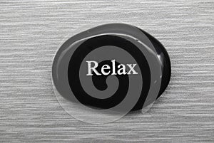 Black Relax mood stone on grey background