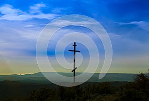 Black religion symbol silhouette Jesus Christ wooden cross on a background with colorful mountain sunset, Easter concept