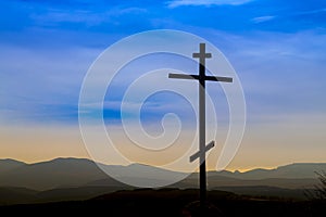 Black religion symbol silhouette Jesus Christ wooden cross on a background with colorful mountain sunset, Easter concept