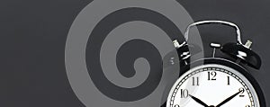 Black retro alarm clock on gray dark background top view Flat lay copy space. Minimalistic background, concept of time, deadline,