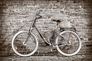 Black retro vintage bicycle with old brick wall