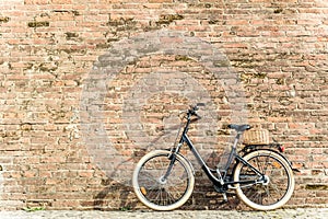 Black retro vintage bicycle with old brick wall.