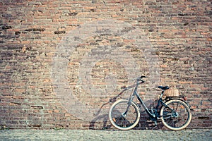 Black retro vintage bicycle with old brick wall.