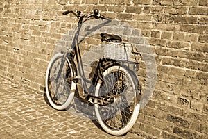 Black retro vintage bicycle with old brick wall.