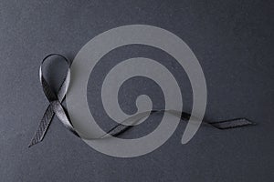 Black ribbon on dark background, top view with space for text.