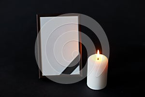 Black ribbon on photo frame and candle at funeral