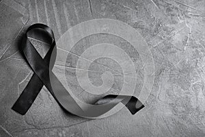 Black ribbon with space  text on grey stone background, top view. Funeral symbol