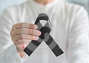 Black Ribbon symbolic bow color raising awareness on Melanoma and skin cancer prevention, sleep disorder