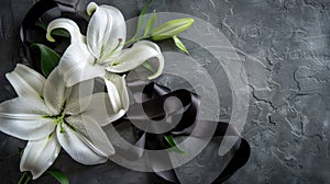 a black ribbon and white lily flowers arranged on a grey concrete surface, the poignant symbolism of the sad flag in