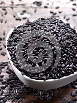 Black rice cereals on wooden background