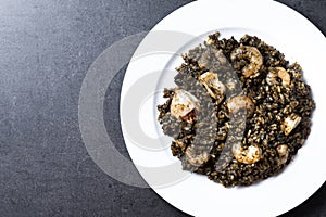 Black rice with seafood on black background