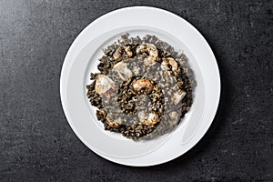 Black rice with seafood on black background