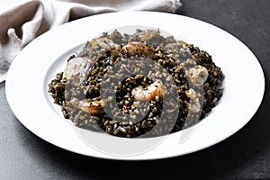 Black rice with seafood on black background