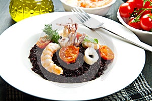 Black rice with sliced squids , prawns and tomato