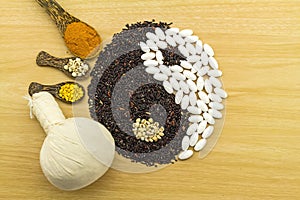 Black rice and white pill forming a yin yang symbol and Spa herbal