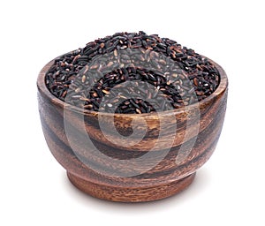 Black rice in wooden bowl isolated on white background