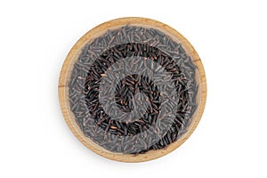 Black rice in a wooden bowl isolated on white background. Top view. Flat lay