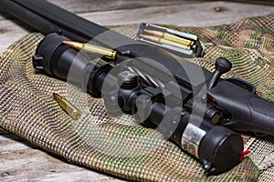 The Black Rifle with ammo and scope on the multicam background. Close up