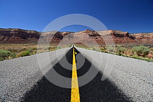 Black road and yellow carriageway marking in mountains