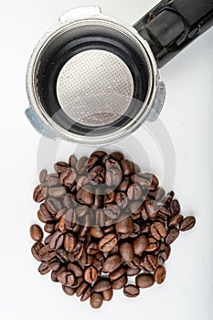 Black roasted coffee beans and a coffee machine flask. Coffee making accessories