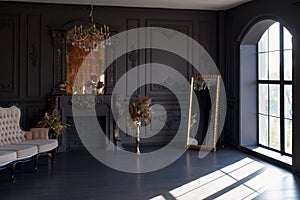 Black room interior with a vintage sofa, chandelier, mirror and fireplace