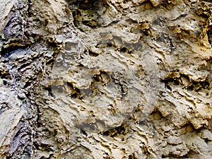Black and rough rough texture of the stone with depressions and pits on the surface