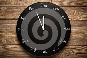 Black round clock calendar. 12 months.