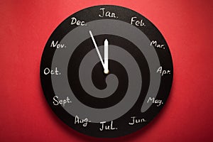 Black round clock calendar. 12 months.