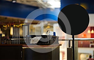 Black round shape mockup with stand beside counter bar shop