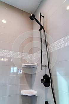 Black round shower head and handle inside the walk in bathroom shower stall