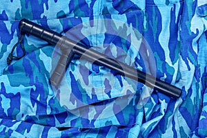 Black rubber baton on blue urban russian riot police camouflage flat lay