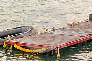 Black rubber dinghy tied to dock