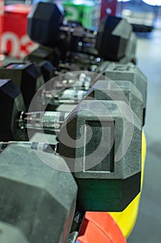 Black rubber dumbbells. Hexagonal heavy duty weight set used for serious hardcore gym workouts, cross fit training and