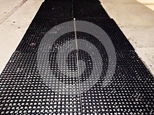 Black rubber floor covering on a gray background