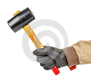 Black rubber hammer with wooden handle in worker hand in black protective glove and brown uniform isolated on white background