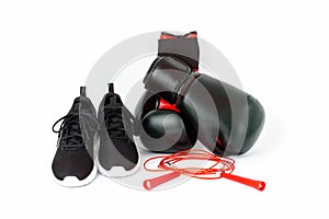 Black running shoes, boxing gloves and red jumping rope isolated on white background