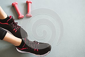 Black running shoes with fitness accessories on a grey background