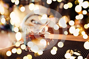 Black russian cocktail with festive bokeh lights