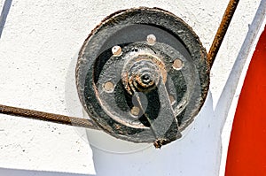 A black and rusty wheel with a chain on it