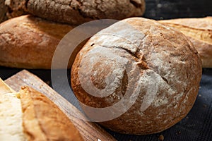 Black rye round bread on table blur white