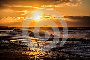 Black sand beach with waves and sunrise