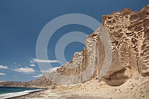 Black sand beach with wind carved cliffs