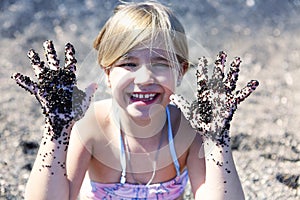 Black sand on children`s hands