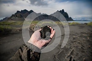 Black sand on hand and Vestrahorn Background , Iceland Summer.