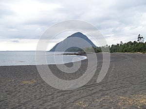 Black sand, peaceful place, grey clouds in Santa Barbara's beach Chili photo