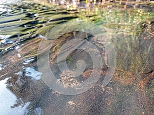 The black sand on the river forms a unique texture