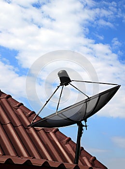 Black satellite dish on house roof