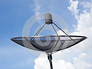 Black satellite dish or TV antennas install on the house roof on blue sky cloudy background