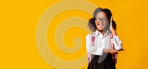 Black Schoolgirl Raising Hand Posing In Studio On Yellow Background