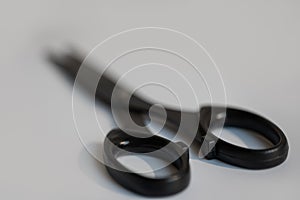 Black scissors lie on a white background